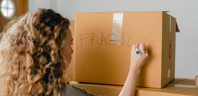 Woman writing on a carton box with a marker